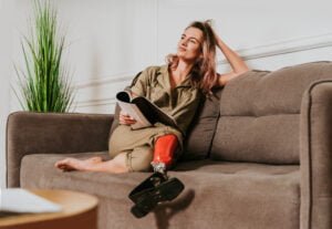 Woman with bionic leg sitting on sofa