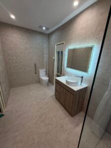 Photo of a renovated bathroom by Restore Home Modifications. Next to the toilet there is a grab rail for accessibility.
