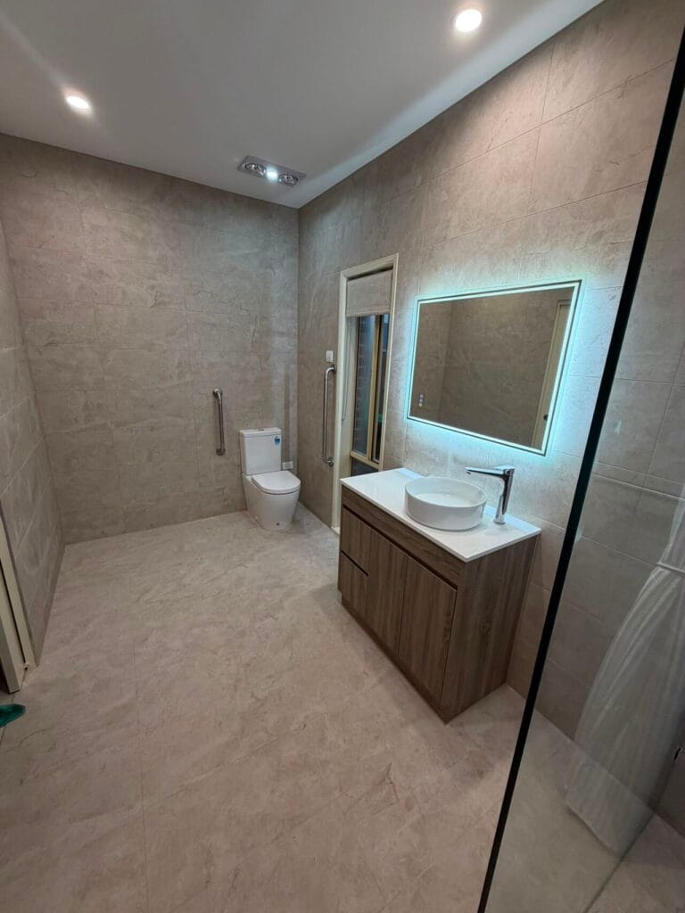 Photo of a renovated bathroom by Restore Home Modifications. Next to the toilet there is a grab rail for accessibility.