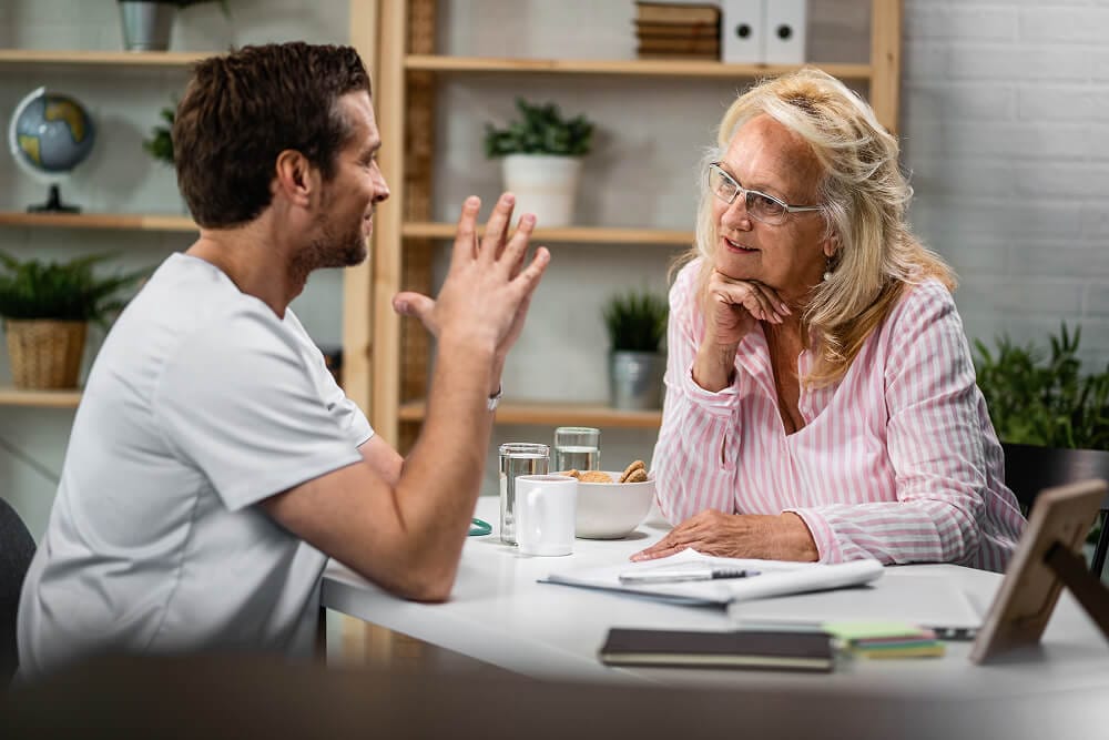 Photo of an occupational therapist and a builder discussing an NDIS home modification scope of work